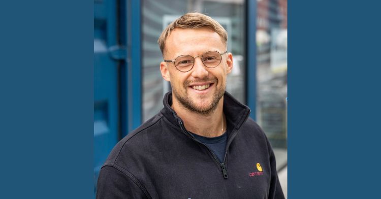picture shows a man (freddie) with blonde hair and glasses, smiling at the camera