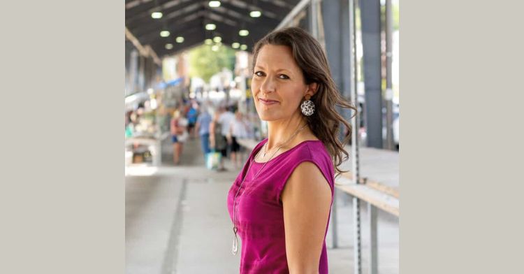 image shows a woman in purple, turned to the side smiling at the camera